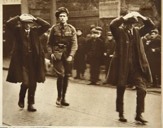 Dois membros do Sinn Fein sendo presos por tropas britânicas durante uma incursão nos escritórios do Ministério do Trabalho em Dublin, 1920 (foto sépia)